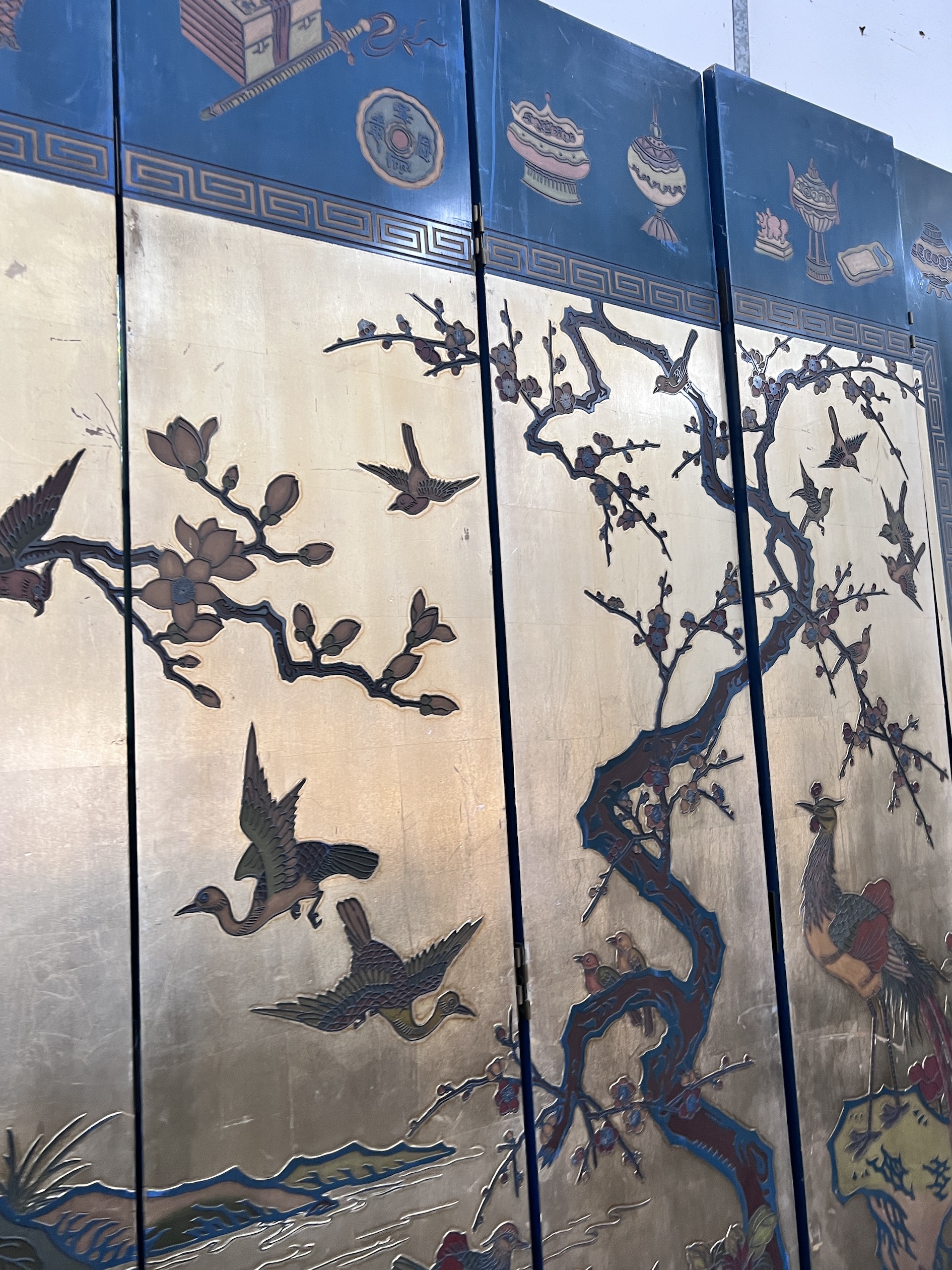A Chinese lacquered eight fold screen decorated with exotic birds among flowering trees, each panel width 40cm, height 244cm (no fixing clips)